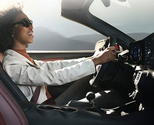 A Woman Driving A Mustang Vehicle Having Nice Interior