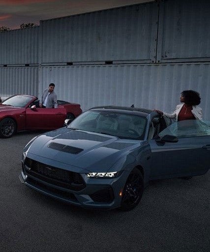 A Couple Entering In A Different Mustang Vehicles