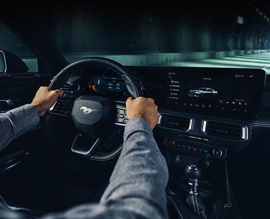 Hand Of A Person Driving A Mustang Vehicle Having Stylish Steering Wheel